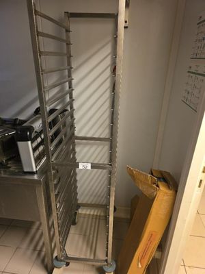 une étagère métallique sur laquelle est posé un micro-ondes, dans une cuisine