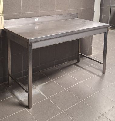 une table en acier inoxydable au milieu d'une pièce carrelée