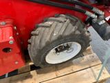 a red tractor that is sitting on a pallet