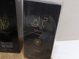 two boxes of perfume sitting on top of a wooden table next to each other