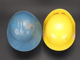 yellow and blue hard hat sitting next to each other on a table