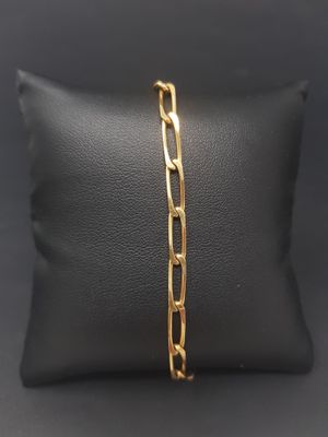 a gold plated bracelet on a black pillow