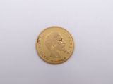 a close up of a gold coin on a white surface