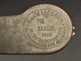 the back of a metal object with a stamp on it