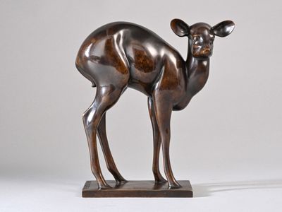bronze sculpture of a deer standing on a wooden base