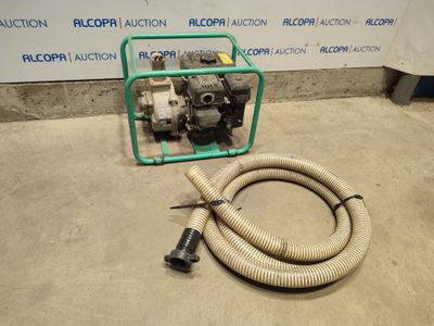 the hose is next to the pump on the floor in front of the wall
