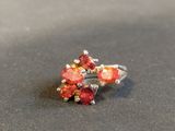sterling silver ring with red stones on a black surface