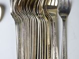 a lot of forks and spoons that are on the table