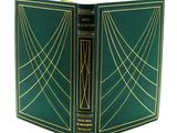 un vieux livre à la couverture verte ornée de lignes dorées
