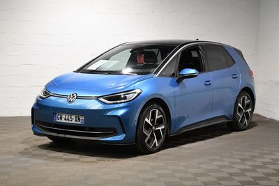 une voiture bleue est garée dans une pièce au sol à carreaux