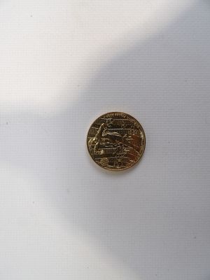 a gold coin with a picture of a ship on it