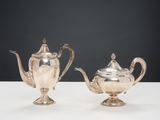 deux théières en argent et un sucrier posés sur une table
