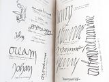 a person holding an open book with writing on it