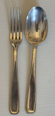 deux cuillères et une fourchette en argent sur une table
