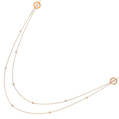 a gold chain necklace with a circular design on a white background