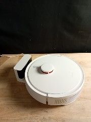 un faitout blanc avec un couvercle posé sur une table en bois