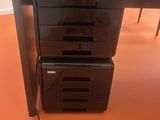 deux tiroirs noirs situés sous un bureau sur lequel se trouve un ordinateur