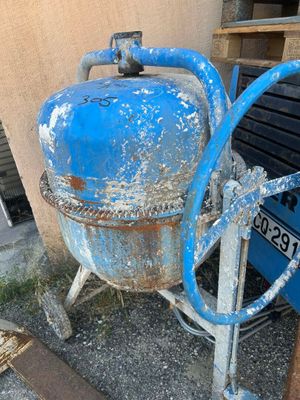 un réservoir bleu muni d'un tuyau, situé à côté d'un bâtiment
