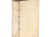 an old book sitting on top of a white table next to a white wall