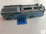 un petit bus en plastique posé sur une table, avec une étiquette de prix