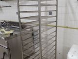 a metal rack with a bunch of pans on it in a kitchen