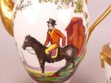 a gold teapot with a picture of a man on a horse