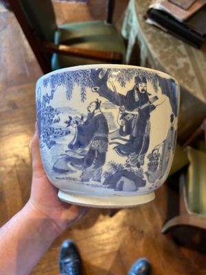 une personne tenant un bol bleu et blanc sur une table