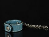 blue leather wrist cuff with chain on a black background