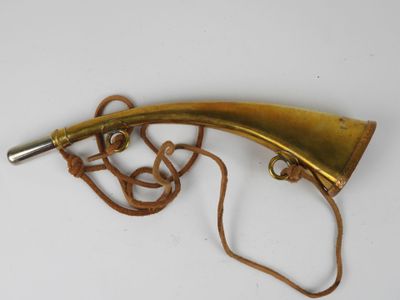 an old brass horn with a rope around it on a white surface