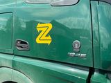 a green truck that has a z logo on the side of it
