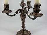 an antique brass candelab with three candles on a white background