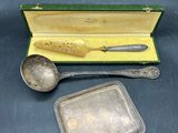 silverware in a case with a spoon and spoon rest in it