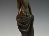 bronze statue of a seated man with a draped cloth around his neck