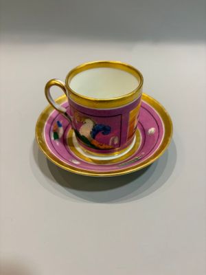 a cup and saucer sitting on a white table