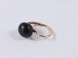 a close up of a black stone ring on a white surface