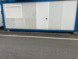 un petit bâtiment bleu et blanc au bord de la route
