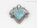 a close up of a blue heart shaped broochle on a white background