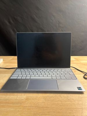 un ordinateur portable ouvert posé sur une table en bois