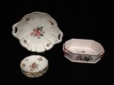 trois pièces en porcelaine sur un fond noir