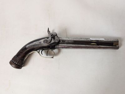 an old gun that is sitting on a white surface