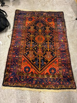 un tapis posé à même le sol dans une pièce, à côté d'une paire de chaussures