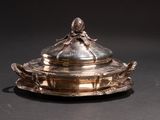 a silver plate with a lid on it on a table