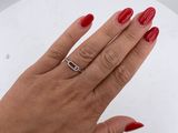woman ' s hand with red manicured nails and a ring on a white plate