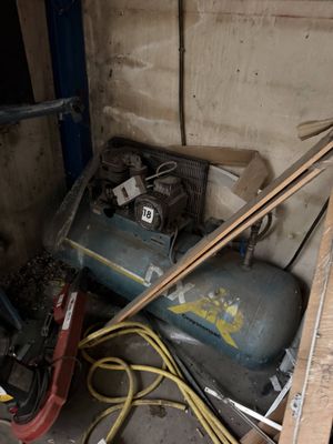 a pile of junk in a garage with a blower and other items