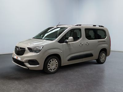 La camionnette argentée est garée dans une pièce blanche au sol noir.