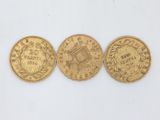 three gold coins, one of which is a sovereign and one of which is a sovereign