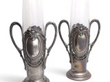 two silver vases that are sitting next to each other