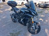 a black motorcycle parked in a parking lot next to some cars
