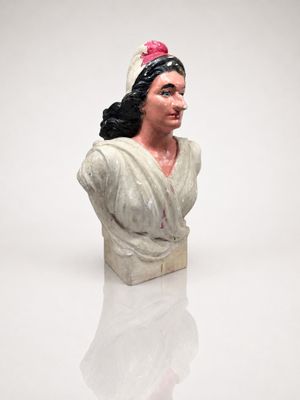 a white busturine of a woman with a pink flower in her hair