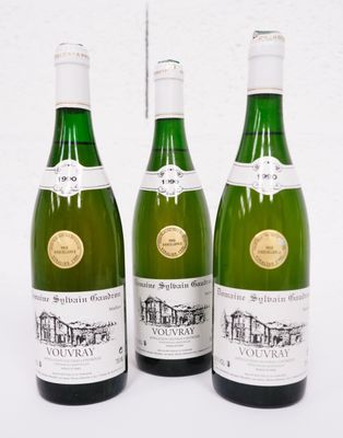 trois bouteilles de vin sont alignées sur une surface blanche